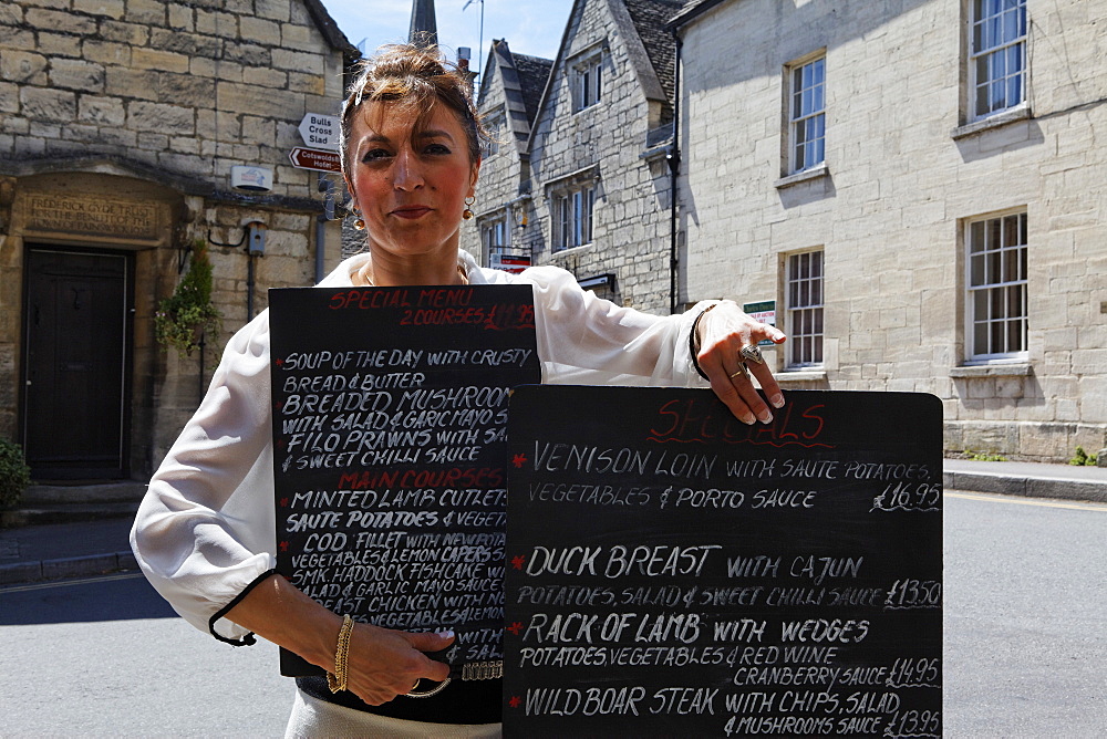 Woman showing the menu of the The Royal Oak Pub, Painswick, Gloucestershire, Cotswolds, England, Great Britain, Europe