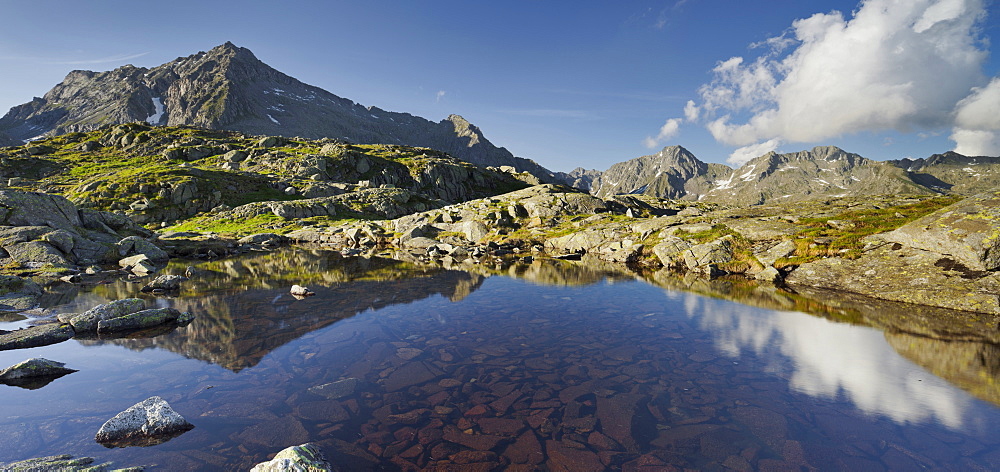 Reflection of the Cima Giner mountain in a mountain lake, Lago Nero, Brenta Adamello Nature Reserve, Trentino, Italy