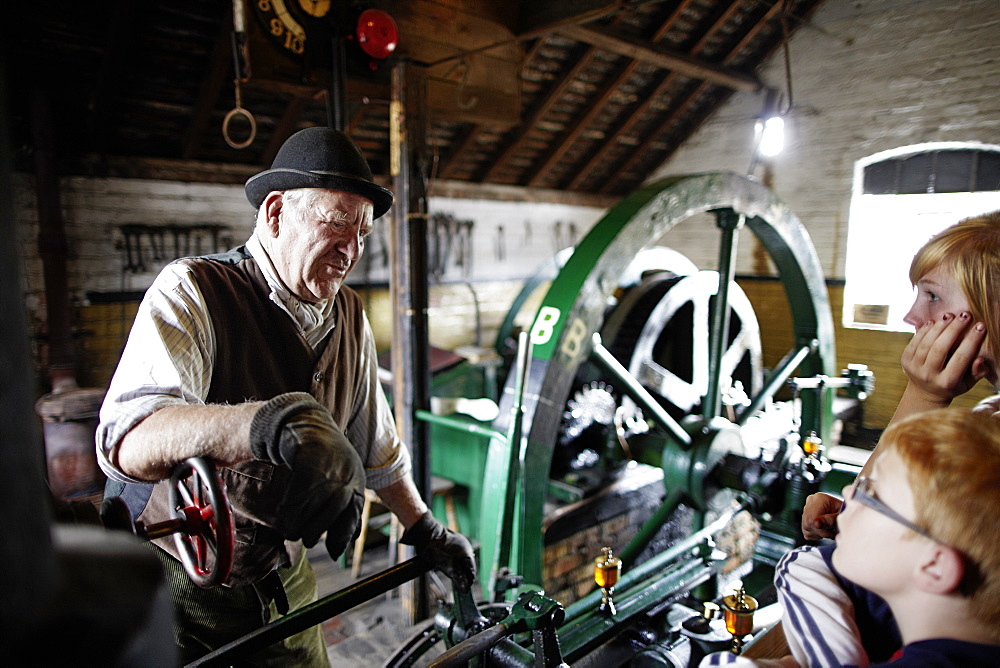 Volunteer explains steampowered flywheel to visitors, The Iron Gorge Museums, Blists Hill Victorian Town, Ironbridge Gorge, Telford, Shropshire, England, Great Britain, Europe