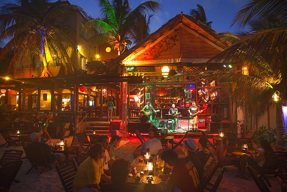 People sitting outside listening to a band playing live music at the Fusion beach bar and restaurant, Playa del Carmen, Riviera Maya, Quintana Roo, Mexico