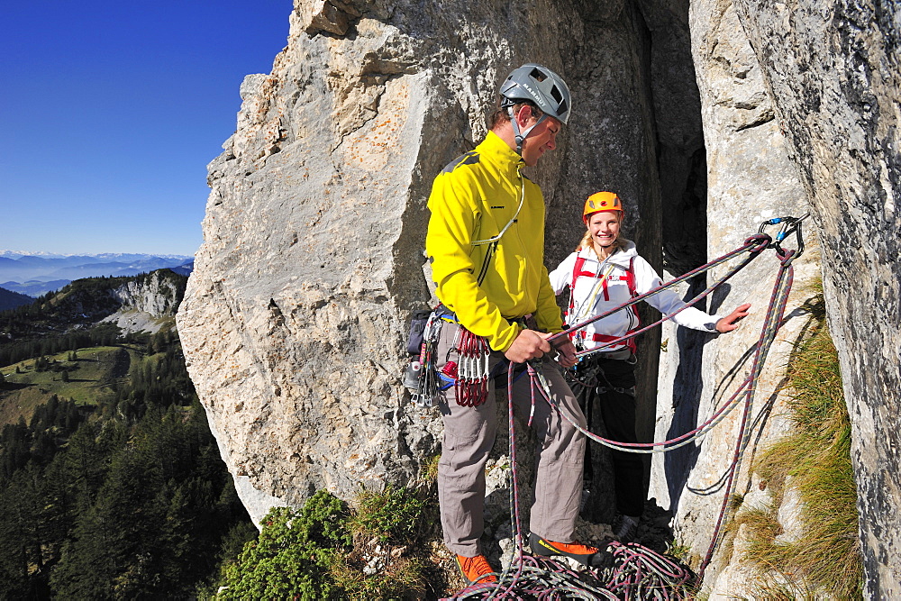 Young man belaying young woman, Kampenwand, Chiemgau Alps, Chiemgau, Upper Bavaria, Bavaria, Germany