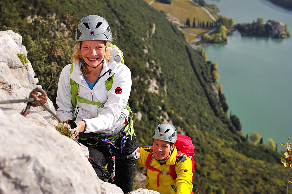 Young woman and young man climbing fixed rope route Rino Pisetta, Lago die Toblino, Sarche, Calavino, Trentino, Trentino-Alto Adige, Suedtirol, Italy