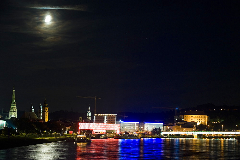 Full moon shining above the illuminated Museum of Modern Art on the Danube, Linz, Upper Austria, Austria