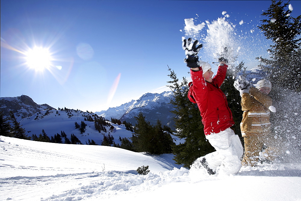 children throwing snow in the air, See, Tyrol, Austria