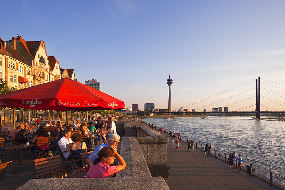 Terrace of a restaurant at the Rhine river promenade in the evening light, Duesseldorf, North Rhine-Westphalia, Germany, Europe