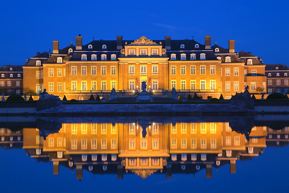 View over the pond onto illuminated Nordkirchen moated castle, Muensterland, North Rhine-Westphalia, Germany, Europe