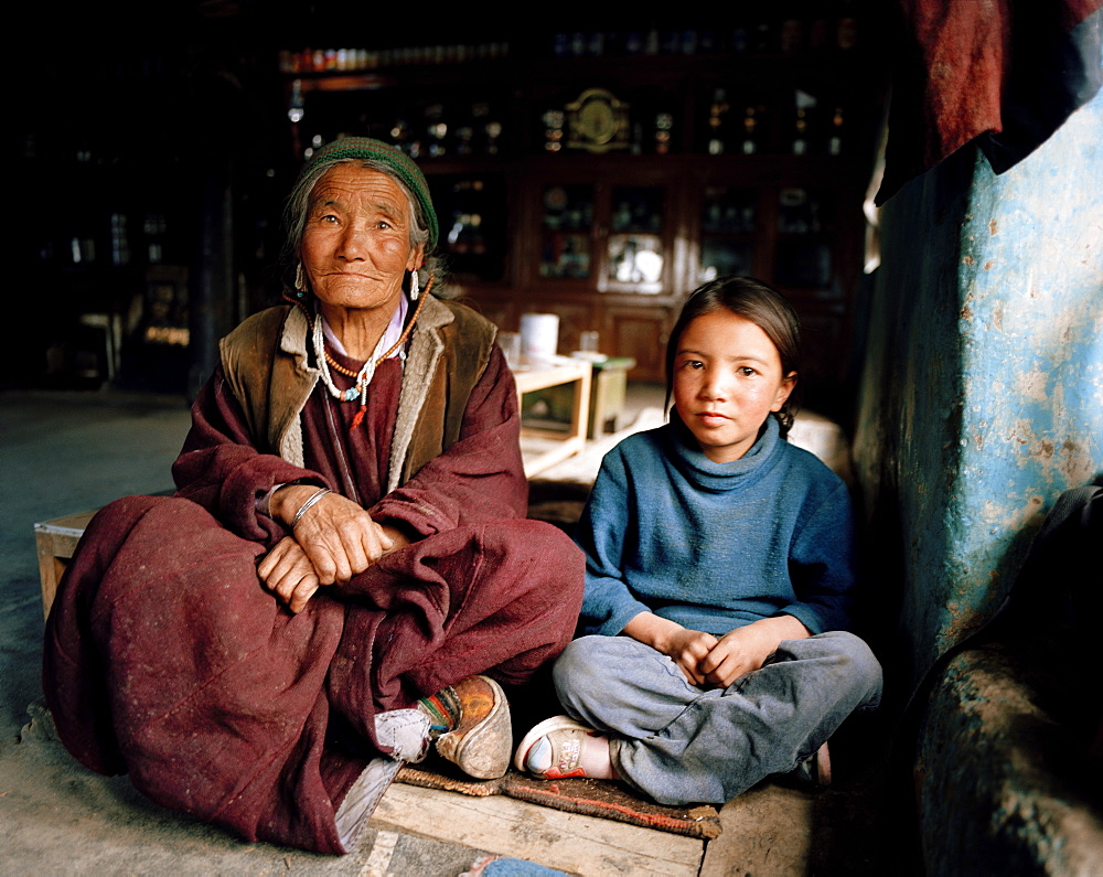 72 year old grandma of family Tsemopa with granddaughter, Ney near convent Thagchockling, Ladakh, Jammu and Kashmir, India