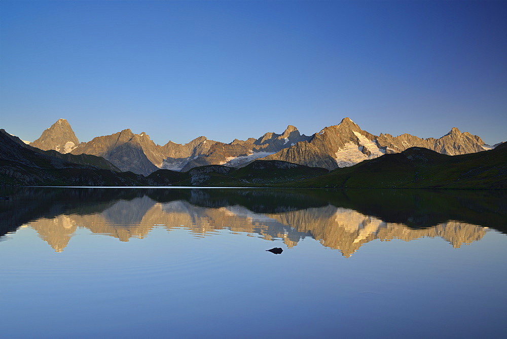 Mont Blanc range with Grandes Jorasses and Mont Dolent reflecting in mountain lake, Pennine Alps, Aosta valley, Italy