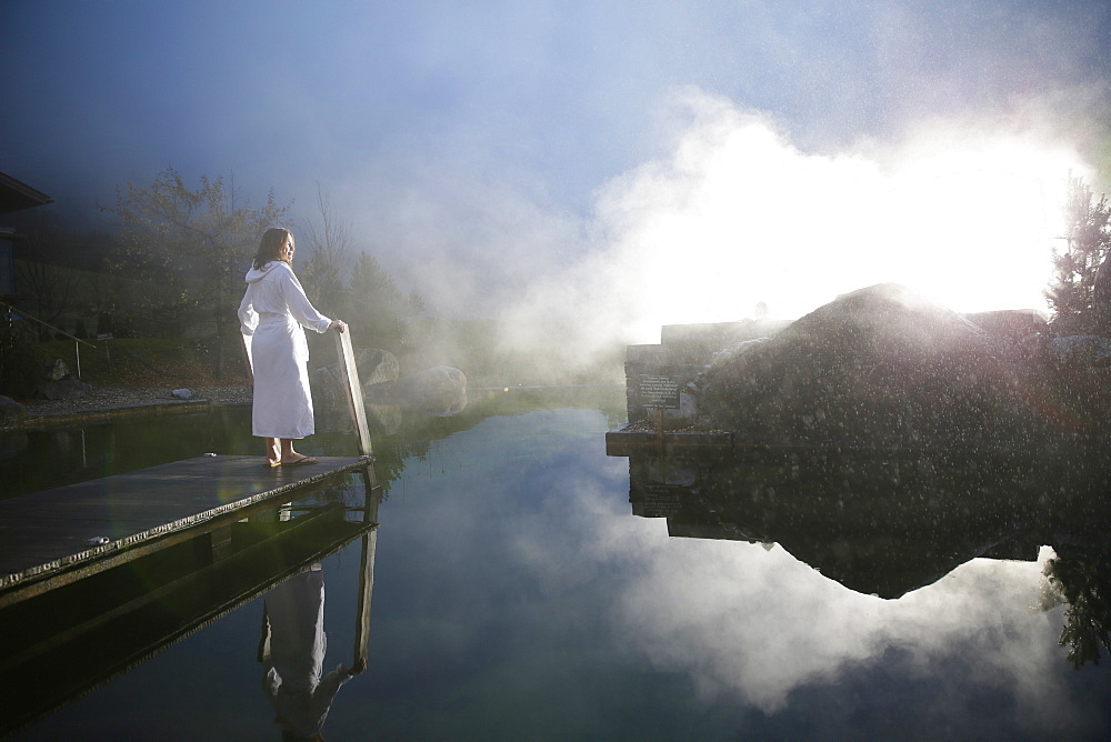 Woman on a jetty at a natural source pond, Tannheim, Tannheim Valley, Tyrol, Austria