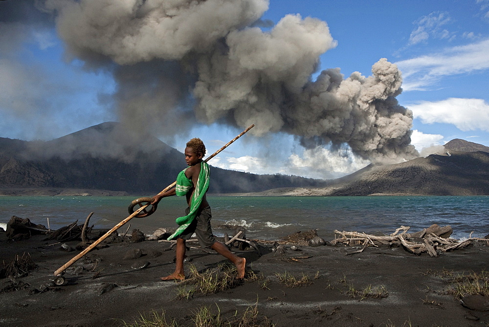 Munganau Buej, 9 years old, loves to play on the beach. Every day the young boy swim in the salt water to rinse off the ash, Tavurvur Volcano, Rabaul, East New Britain, Papua New Guinea, Melanesia- Pacific