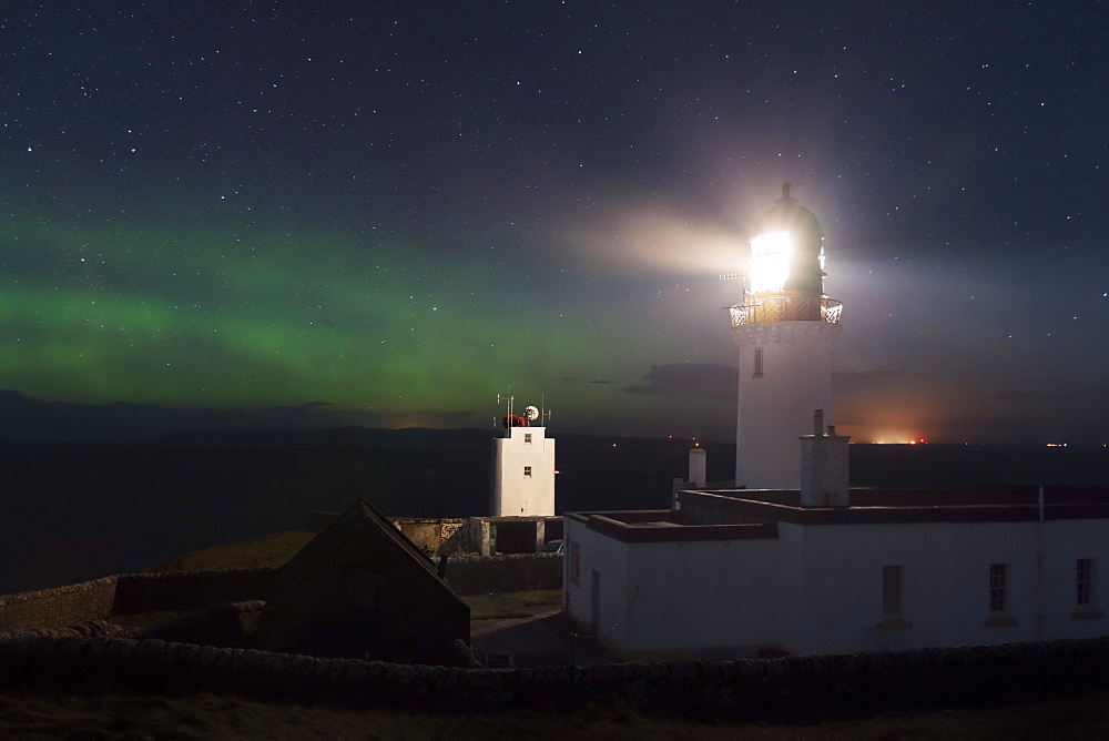 Impressive northern lights, auroras above Dunnet Head lighthouse on the northeast coast of Scotland, United Kingdom