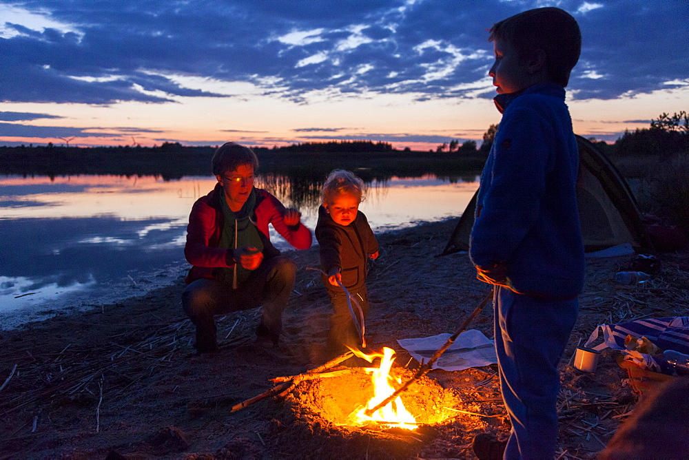Family at campfire, Werbeliner See, Saxony, Germany