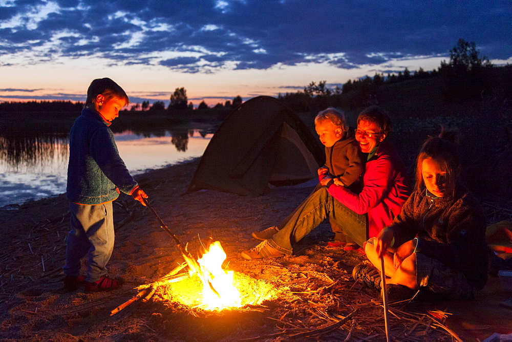 Family at campfire, Werbeliner See, Saxony, Germany