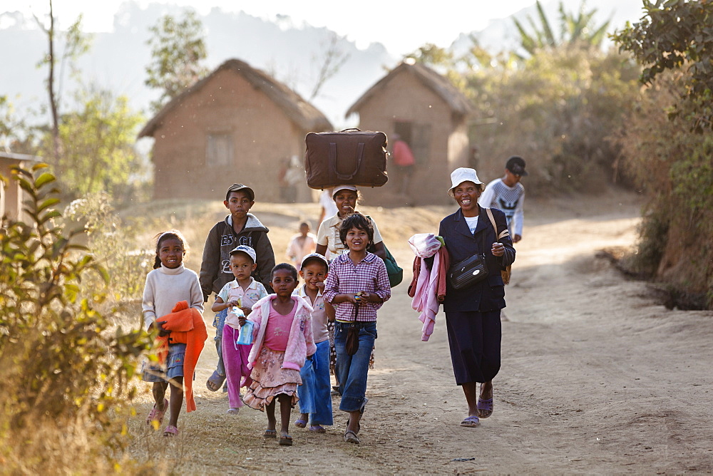 Madagascan people walking along a dusty road near Ampefy, Merina people, Madagascar, Africa