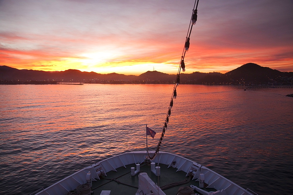 Bow of cruise ship MS Deutschland (Reederei Peter Deilmann) and coastline at sunrise, Manzanillo, Colima, Mexico