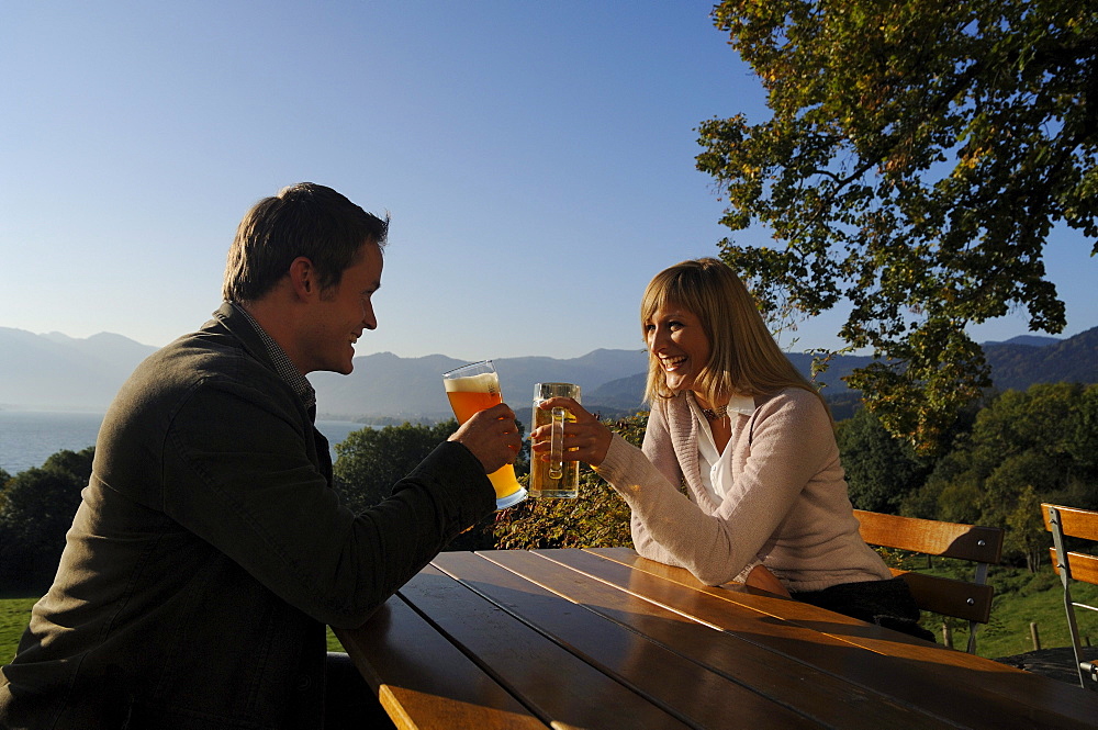 Young couple at a beer garden in the sunlight, lake Tegernsee, Bavaria, Germany, Europe