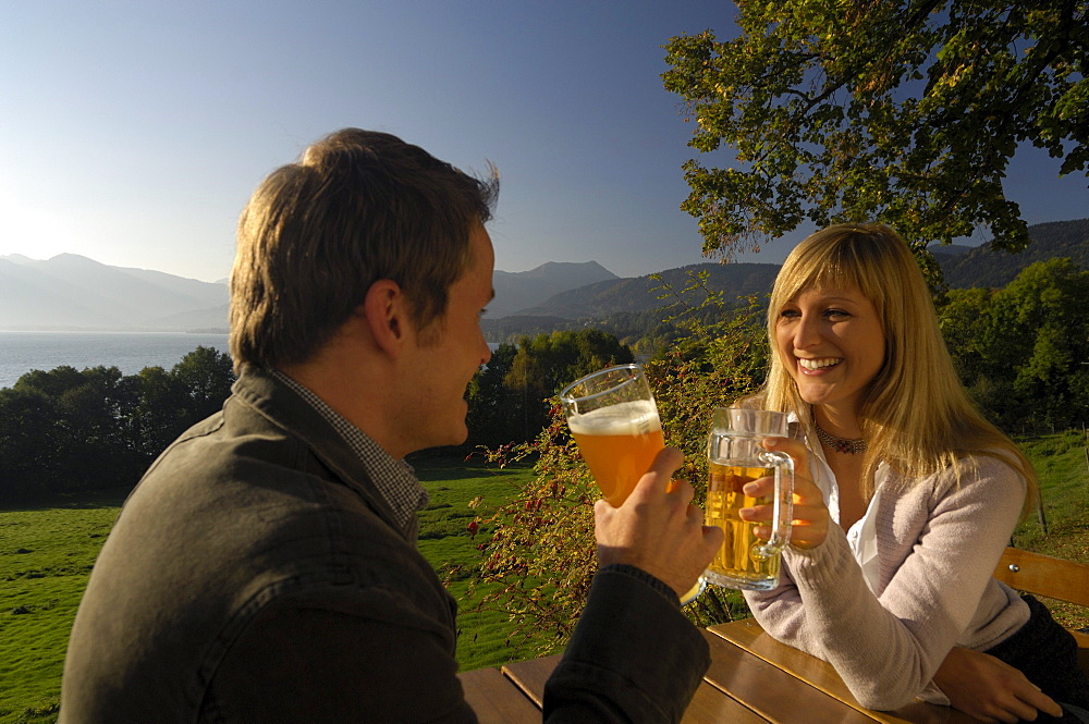 Young couple at a beer garden in the sunlight, lake Tegernsee, Bavaria, Germany, Europe