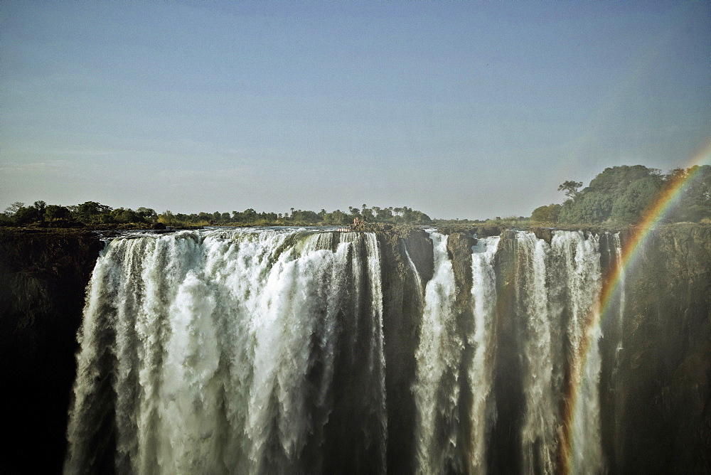 A group of people standing at the edge of Victoria Falls, Sambia, Africa