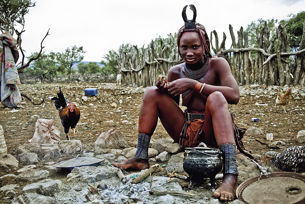 Woman of the Himba tribe sitting at the campfire, Kaokoland, Namibia, Africa