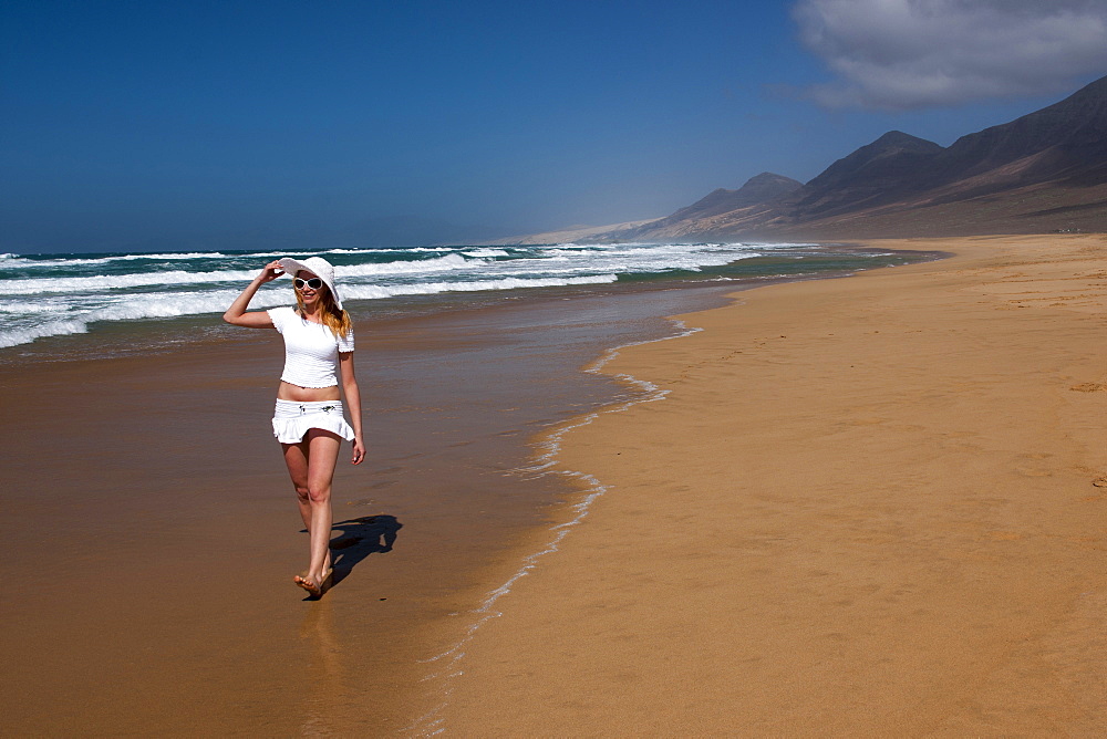 Young woman walking along the beach, Nature Reserve, Jandia, Fuerteventura, Canary Islands, Spain, Europe