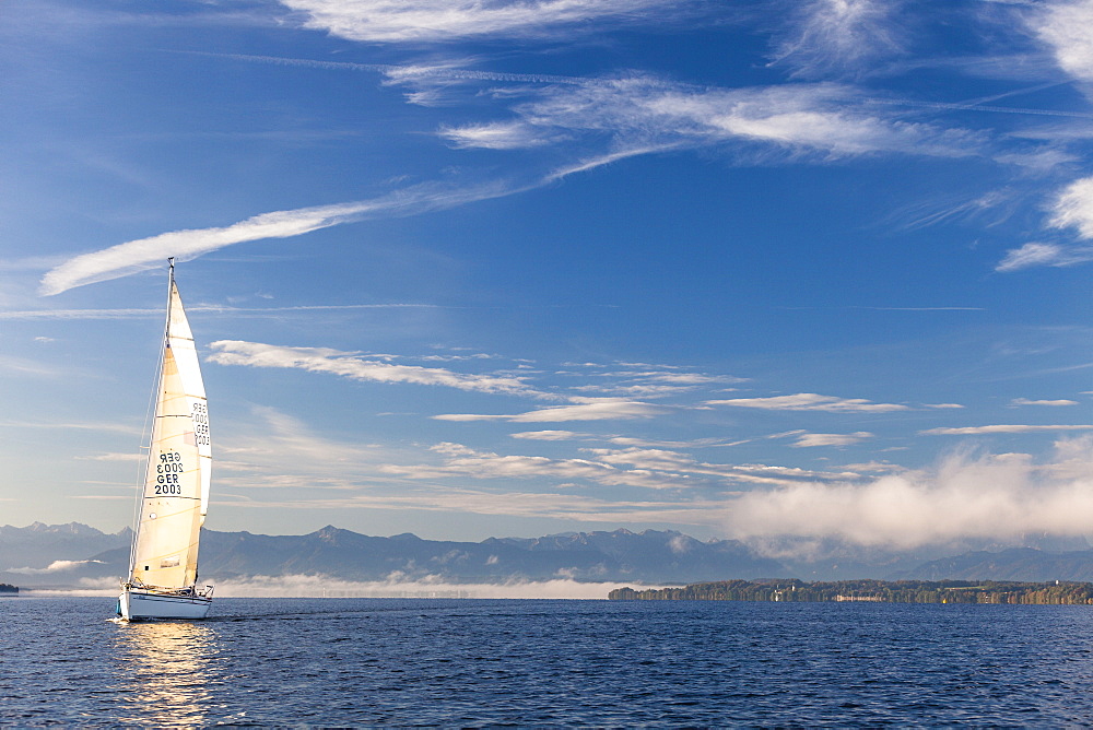 Sailing boat on Lake Starnberg, the Alps in background, Bavaria, Germany