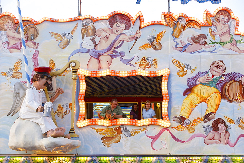 People looking out of a window of the mirrored gallery at the Oktoberfest, Munich, Bavaria, Germany