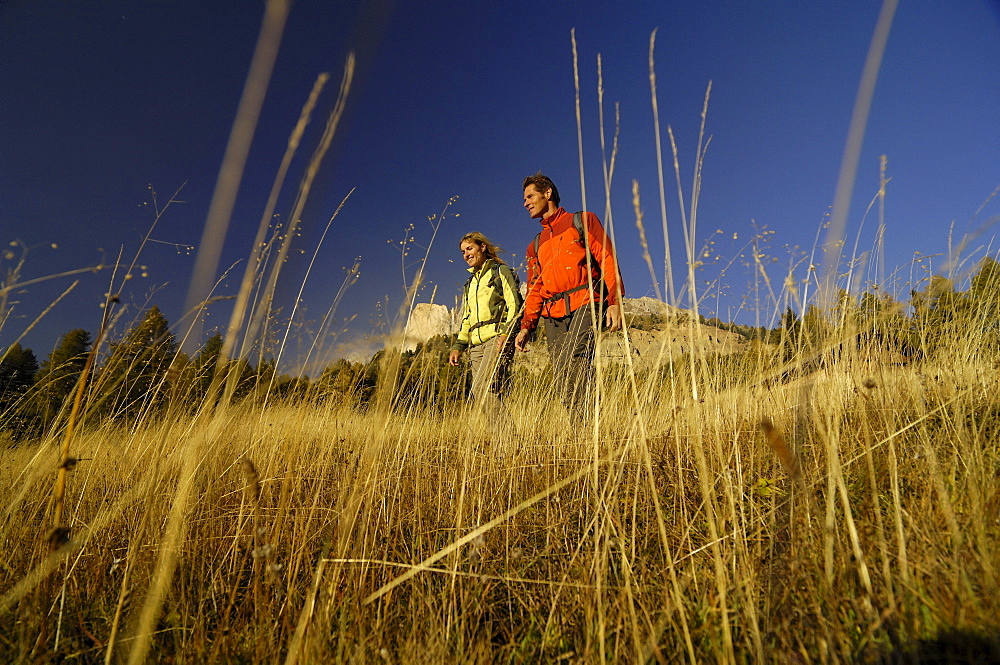 Couple hiking in the mountains, Near Welschnofen, Rosengarten, Dolomites, Trento, South Tyrol, Italy