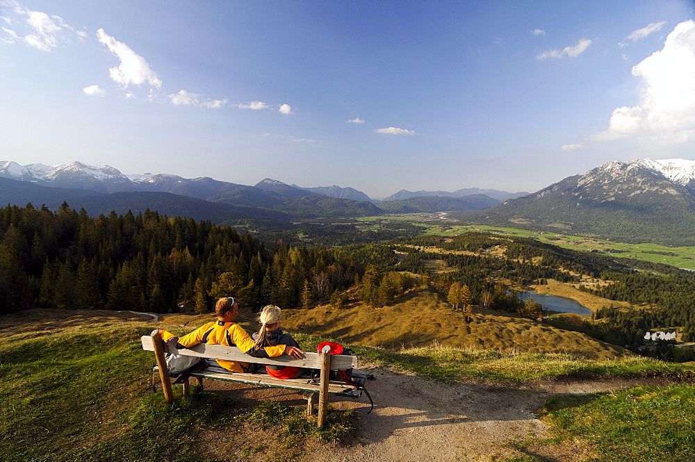 Couple hiking, enjoying the view from Kranzberg, View towards the Karwendel, Mittenwald, Upper Bavaria, Bavaria, Germany, Europe