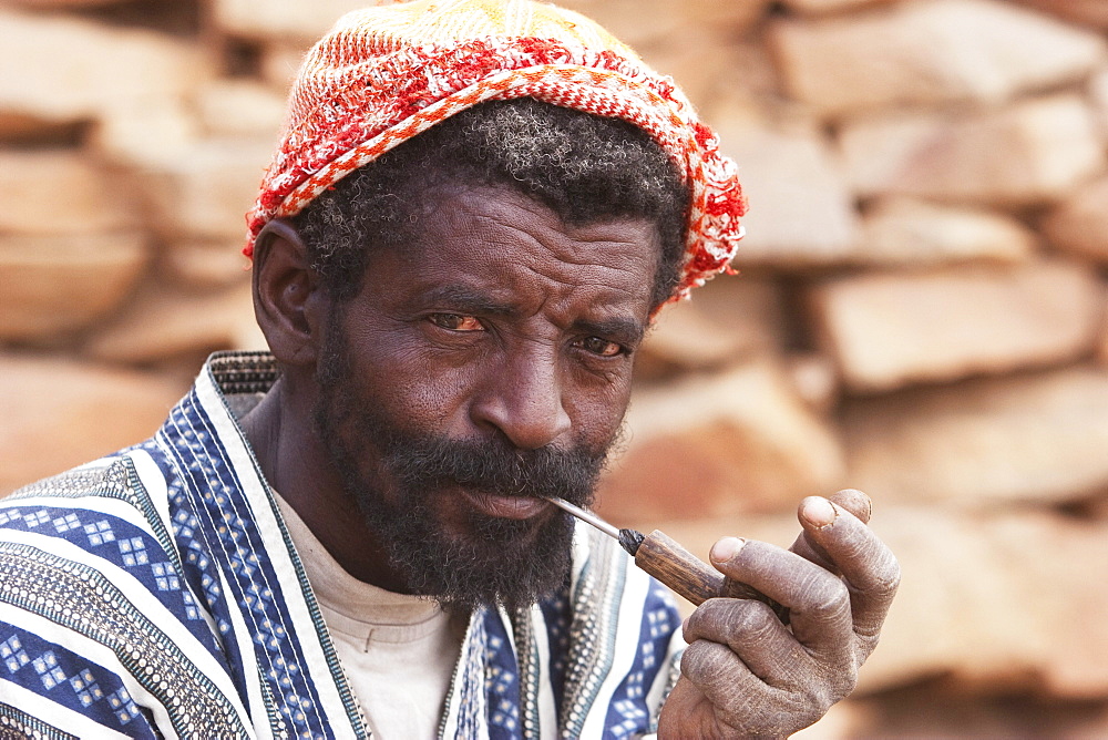 Dogon man smoking a pipe in Tireli, Mali