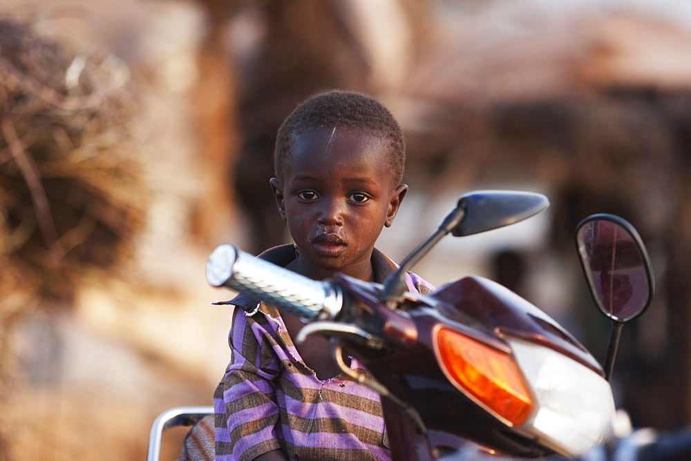 Boy sitting on a motorcycle in Mopti, Mali