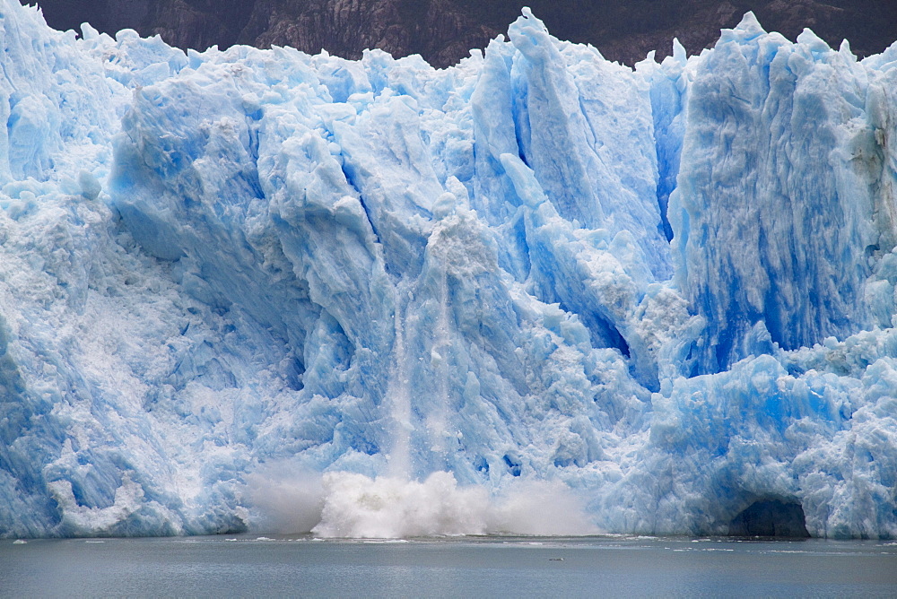 A mass of ice calves from the San Rafael Glacier into Laguna San Rafael, Laguna San Rafael National Park, AisâˆšÂ©n Region, Chile