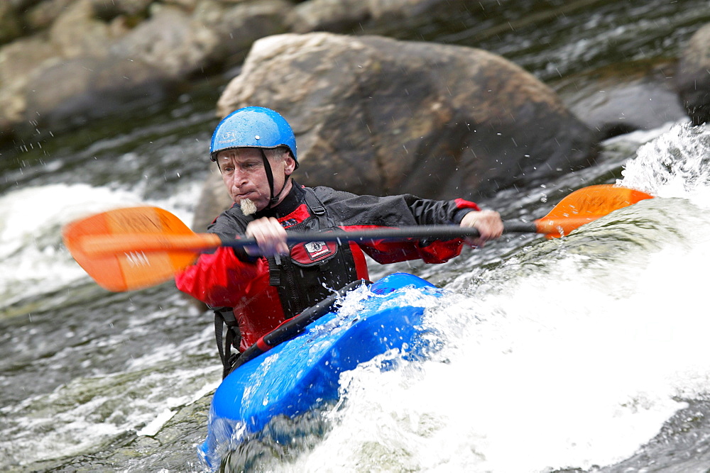 Man Kayaking in White Water.