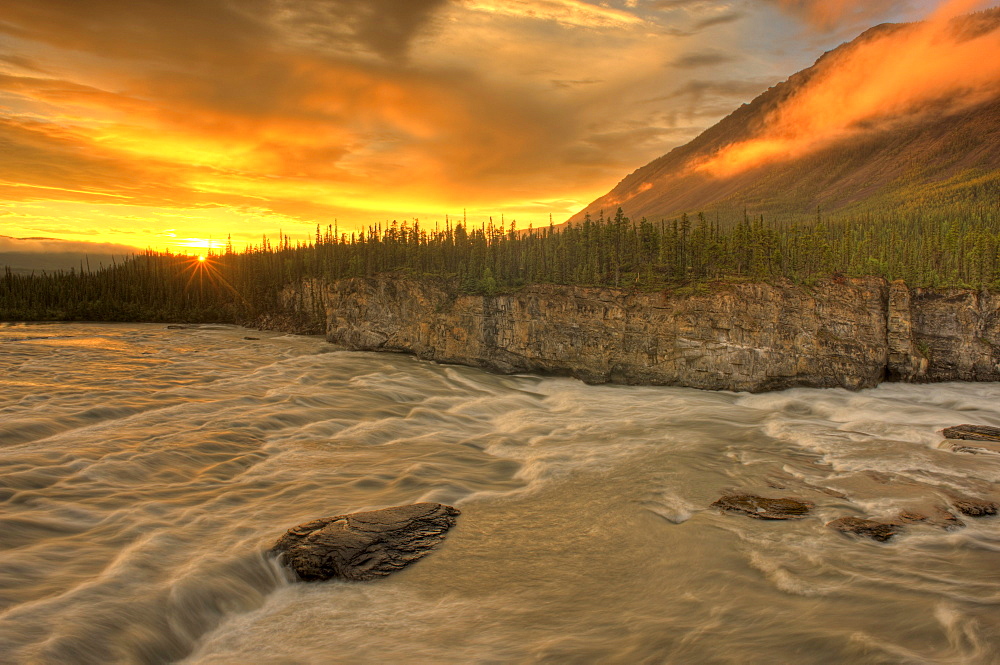 Orange sunset on Sluice Box Rapids above Virginia Falls, Nahanni National Park, Northwest Territories