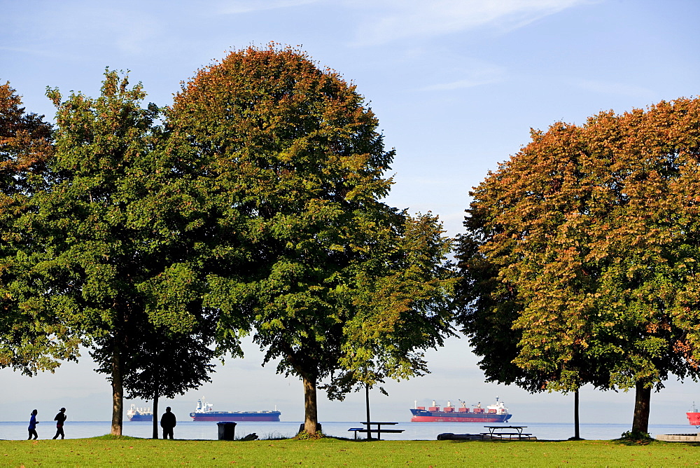 Morning joggers and pedestrians along seawall at Second Beach with English Bay in the background, Stanley Park, Vancouver, British Columbia