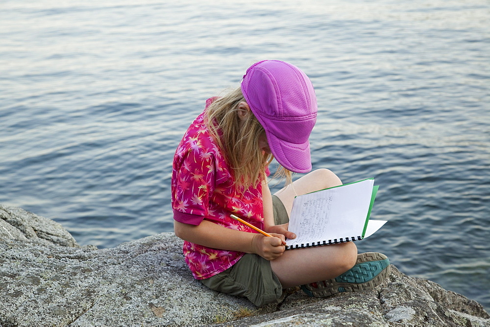 Grade 3 girl taking notes during a school outing, Keats Island, British Columbia