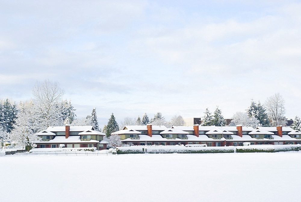 Lakeside town homes with red chimneys covered with freshly fallen snow. Mill Lake, Abbotsford, British Columbia