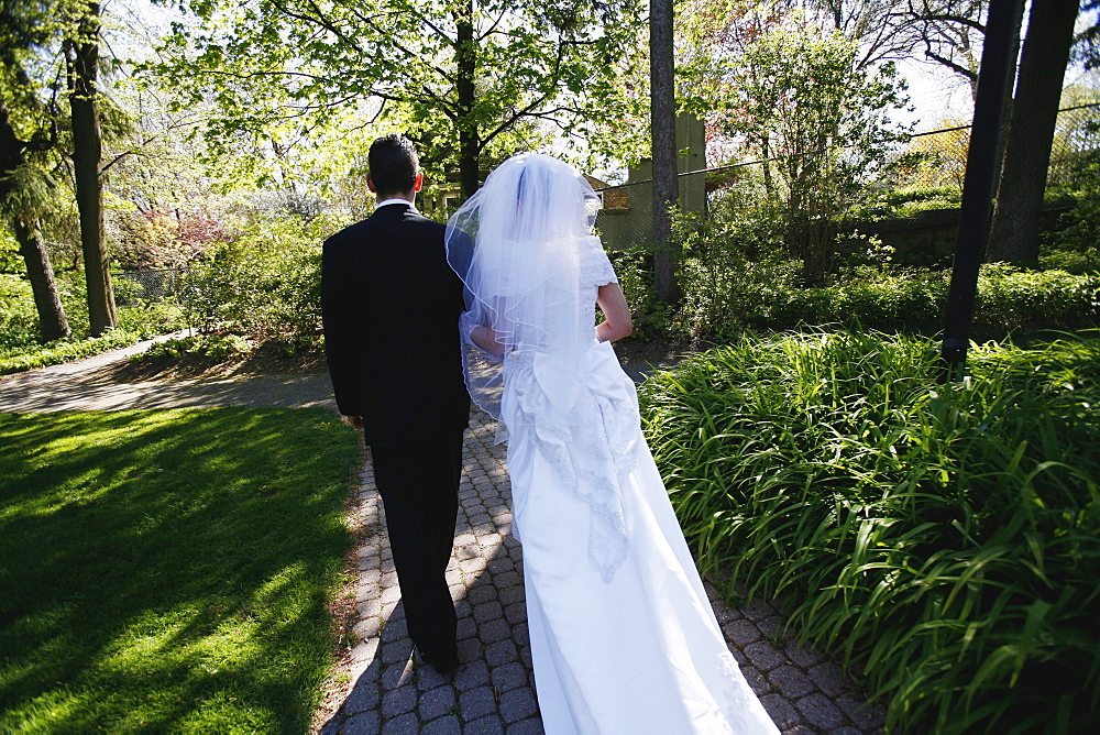 Couple on their Wedding Day Walking down a Path in a Park