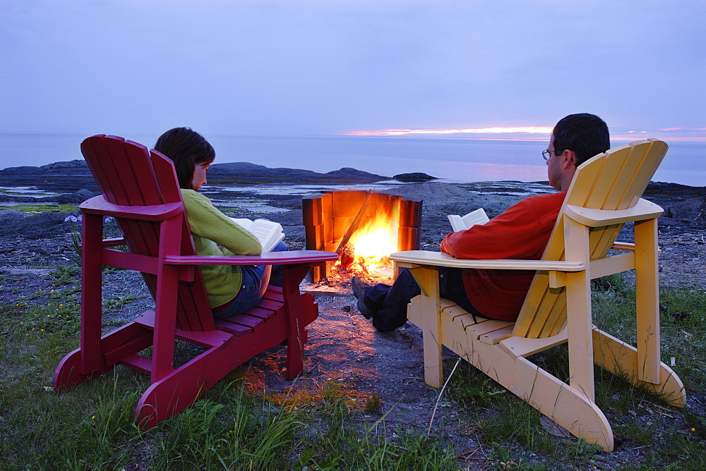 Couple beside Campfire on Border of St. Lawrence River, Pointe-au-Pere, Quebec