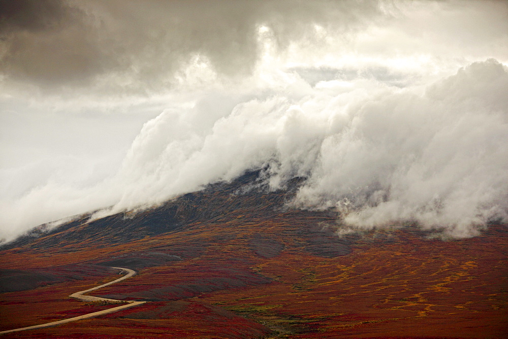 Storm clouds over the Demspter Highway winding its way through the tundra near the Yukon, Northwest Territories border