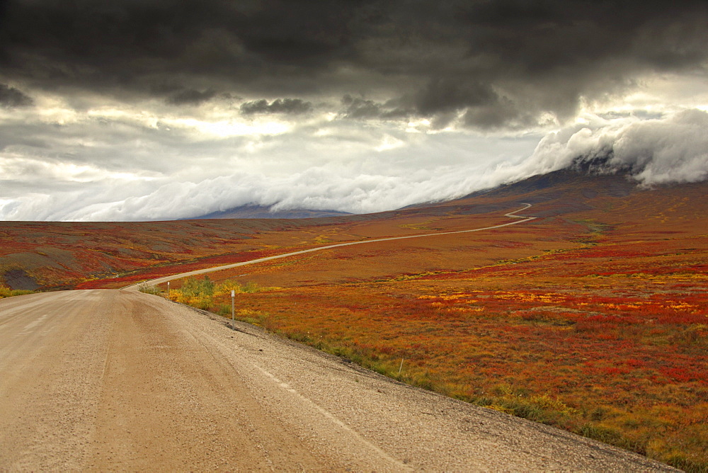 Storm clouds over the Demspter Highway winding its way through the tundra near the Yukon, Northwest Territories border