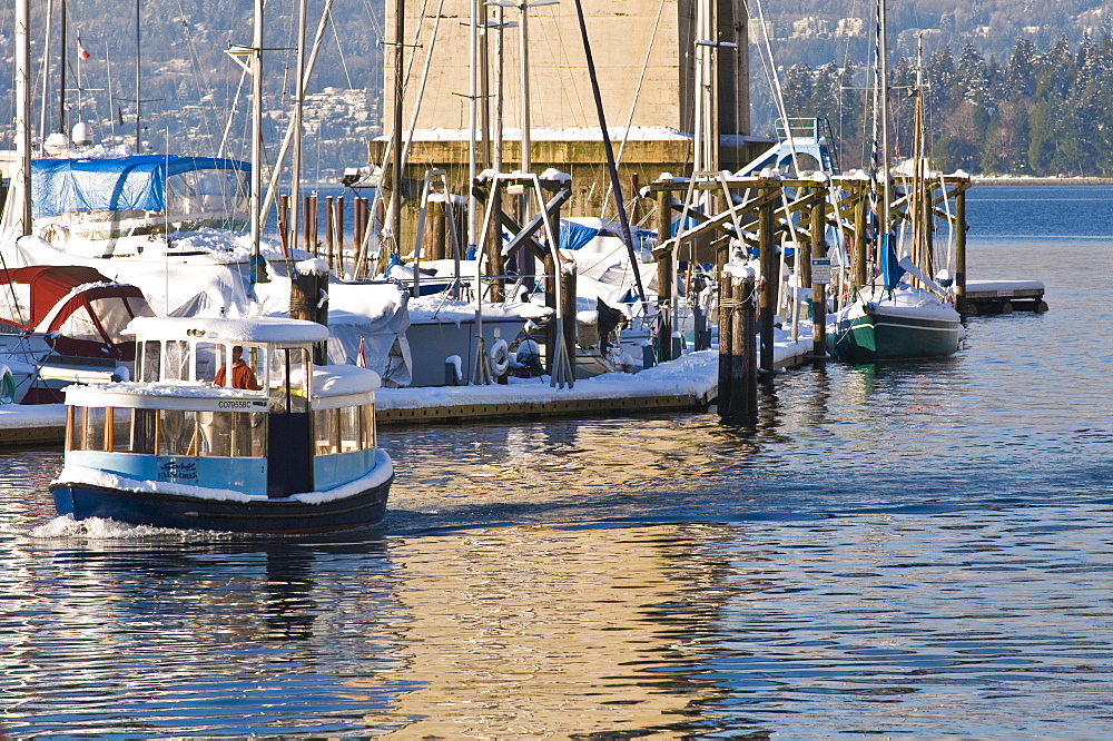 Water taxi passing a harbour after snow fall, Vancouver, British Columbia