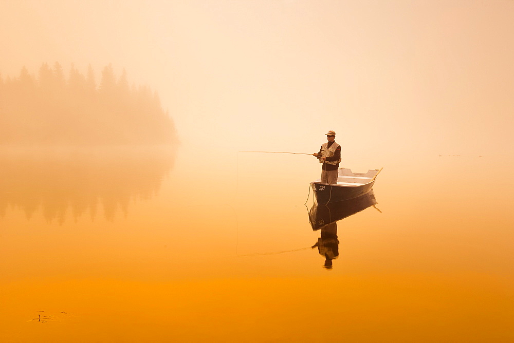 Fisherman in mist at sunrise, Rimouski Lake, Rimouski Wildlife Reserve, Bas-Saint-Laurent region, Quebec