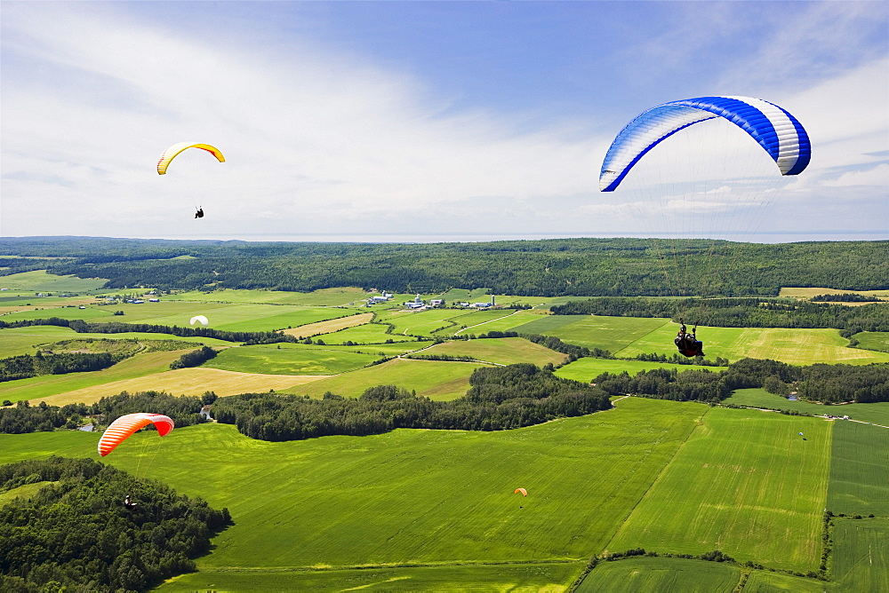 People paragliding over fields, Bas-Saint-Laurent region, Saint-Anaclet, Quebec