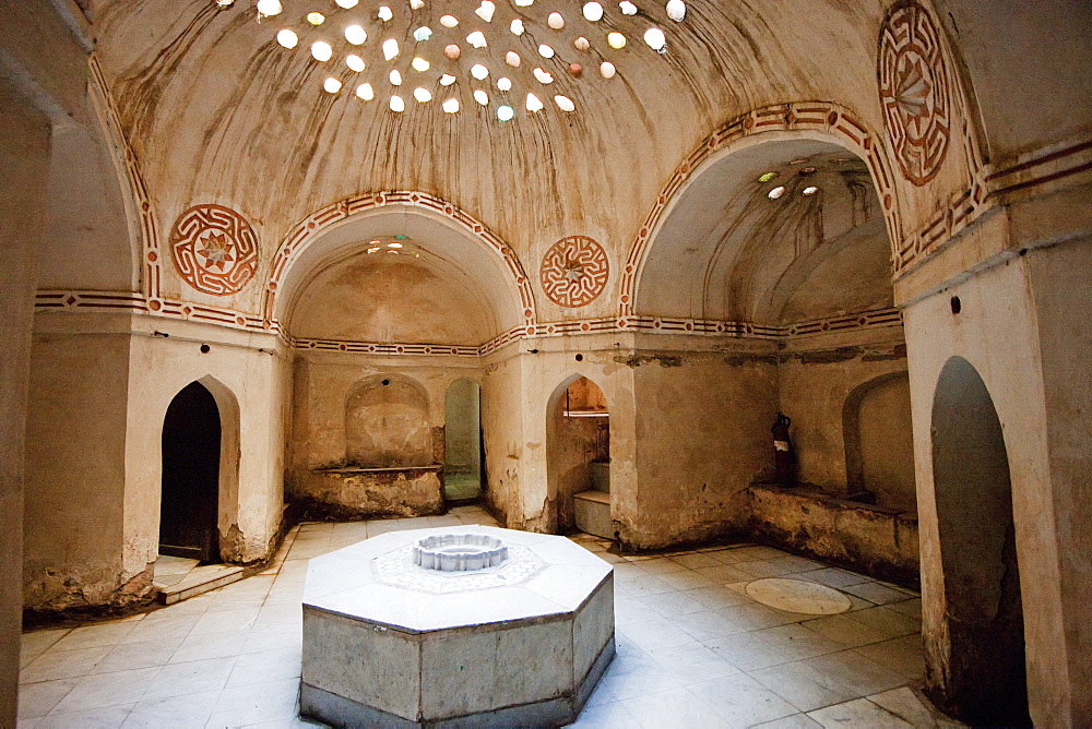 Large marble stone at the center for people to lie on and dome decorated with small glass windows that create a half-light in the sâˆšÃ‘Â¬Â±caklâˆšÃ‘Â¬Â±k (caldarium) of Hammam Azuz, 18th century public baths, Rosetta (Rashid), Beheira, Egypt