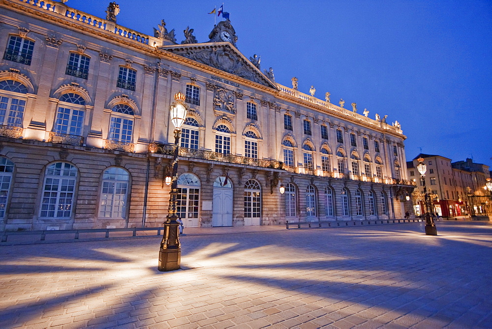 Gilded wrought iron lantern, created by Jean Lamou in front of the Hotel de Ville (City Hall) on Place Stanislas at night, Nancy, France