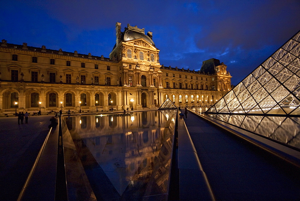 Louvre Pyramid by the architect I.M. Pei and Denon Wing of the Louvre Museum at night, Paris, France