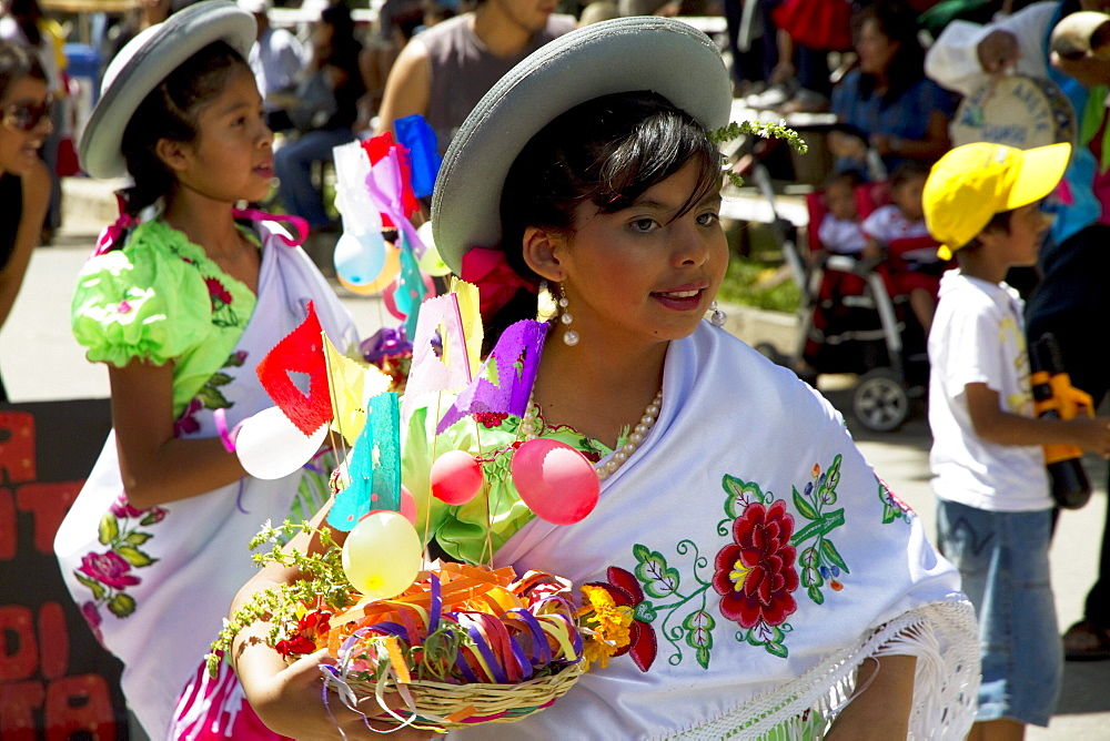 Girls carrying festive baskets in the Entrada de Comadritas parade during the Carnaval Chapaco, Tarija, Bolivia