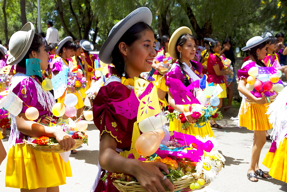 Girls carrying festive baskets in the Entrada de Comadritas parade during the Carnaval Chapaco, Tarija, Bolivia