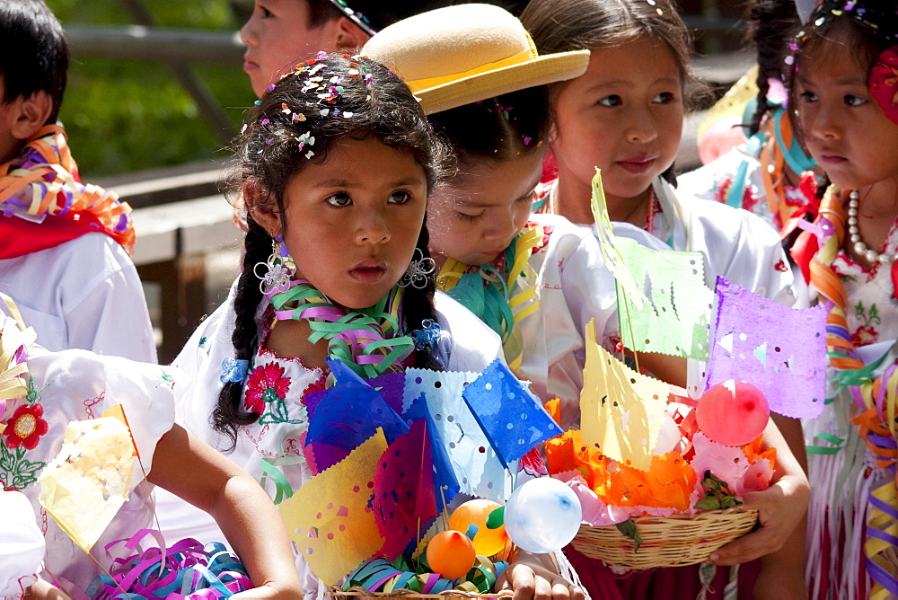 Girls carrying festive baskets in the Entrada de Comadritas parade during the Carnaval Chapaco, Tarija, Bolivia