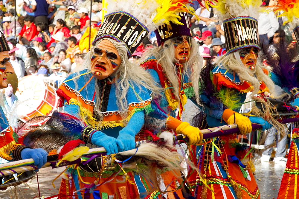 Tobas dancers wearing elaborate masks, feather headdresses and costumes in the procession of the Carnaval de Oruro, Oruro, Bolivia